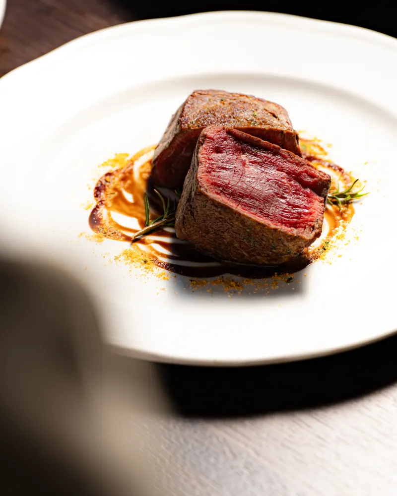 Rindsfilet vom Grill, angeschnitten und rosa gebraten, auf Jus mit Rosmarin