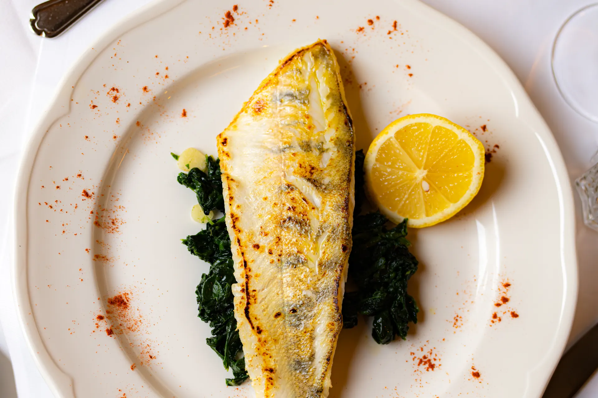 Gebratenes Fischfilet auf Blattspinat mit Zitrone
