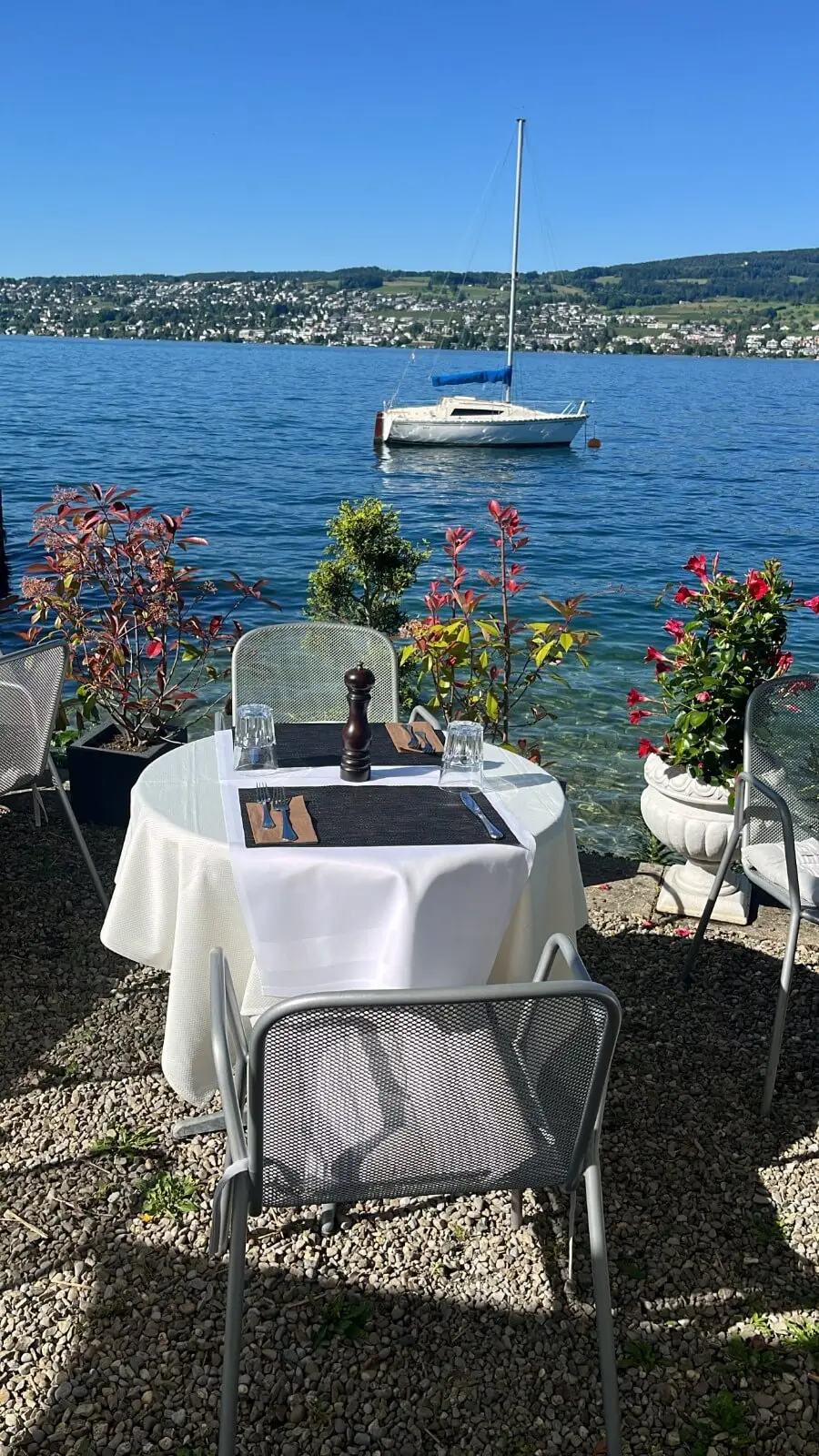 Tisch für zwei am Wasser mit Segelboot auf dem Zürichsee