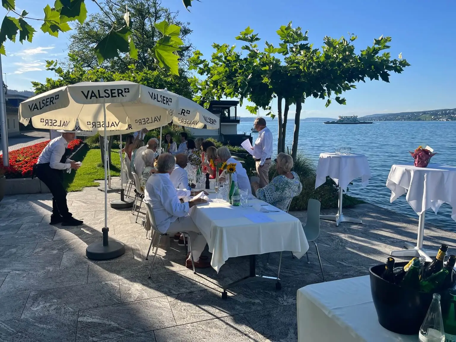 Gäste unter Sonnenschirmen auf der LAGO-Terrasse direkt am Zürichsee in Horgen