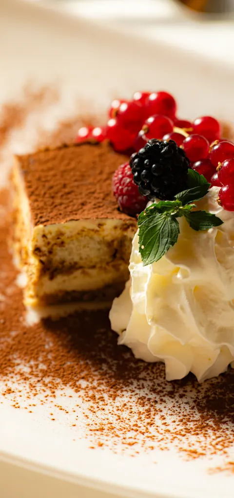 Hausgemachtes Tiramisù mit Kakao, Schlagrahm und frischen Beeren