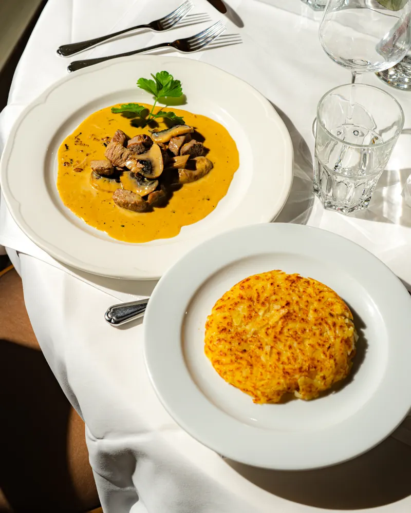 Zürcher Kalbsgeschnetzeltes mit Champignons an Rahmsauce, daneben eine knusprige Rösti